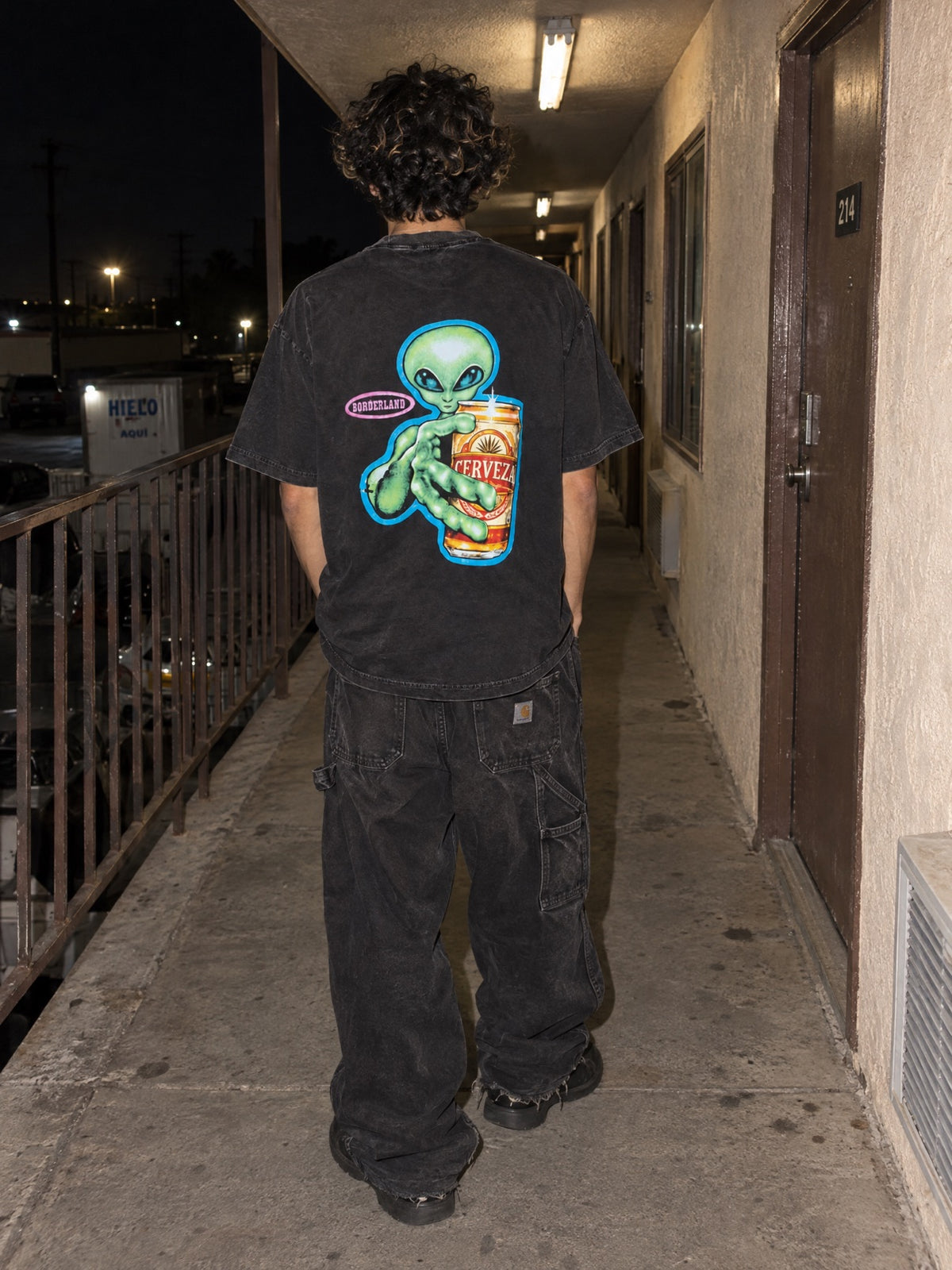 Cerveza tee back print worn at night, green alien holding a cerveza can